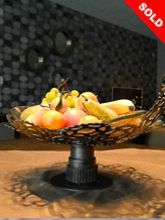 Steampunk fruit bowl: Decorative piece of art made of bicycle gears and melted glass.